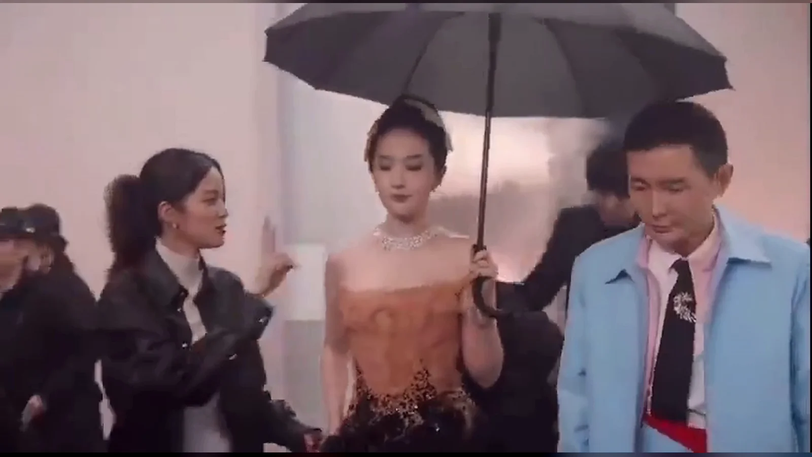 Âu Dương Na Na nói chuyện với Lưu Diệc Phi cầm ô đen ở hậu trường đêm hội Vogue, bên phải là tổng biên tập Lưu Xung