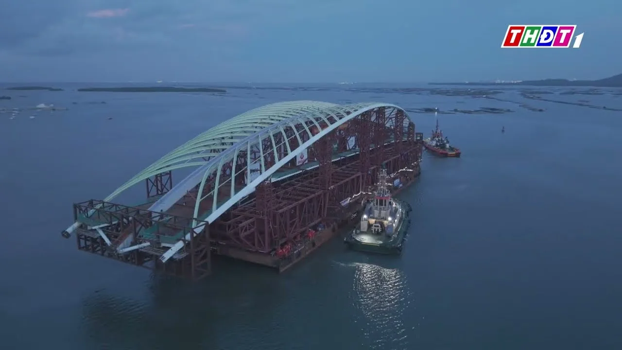 Sà lan chở vòm thép cầu đi bộ lá dừa nước được tàu kéo trên biển, nhìn từ trên cao