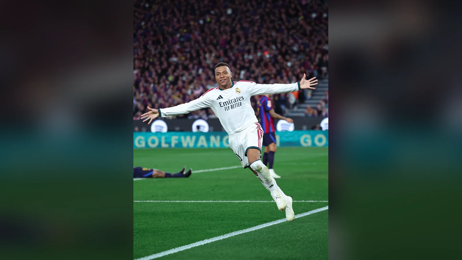 Kylian Mbappé áo trắng Real Madrid dang hai tay ăn mừng bàn thắng trên sân Camp Nou, phía sau là khán đài kín người