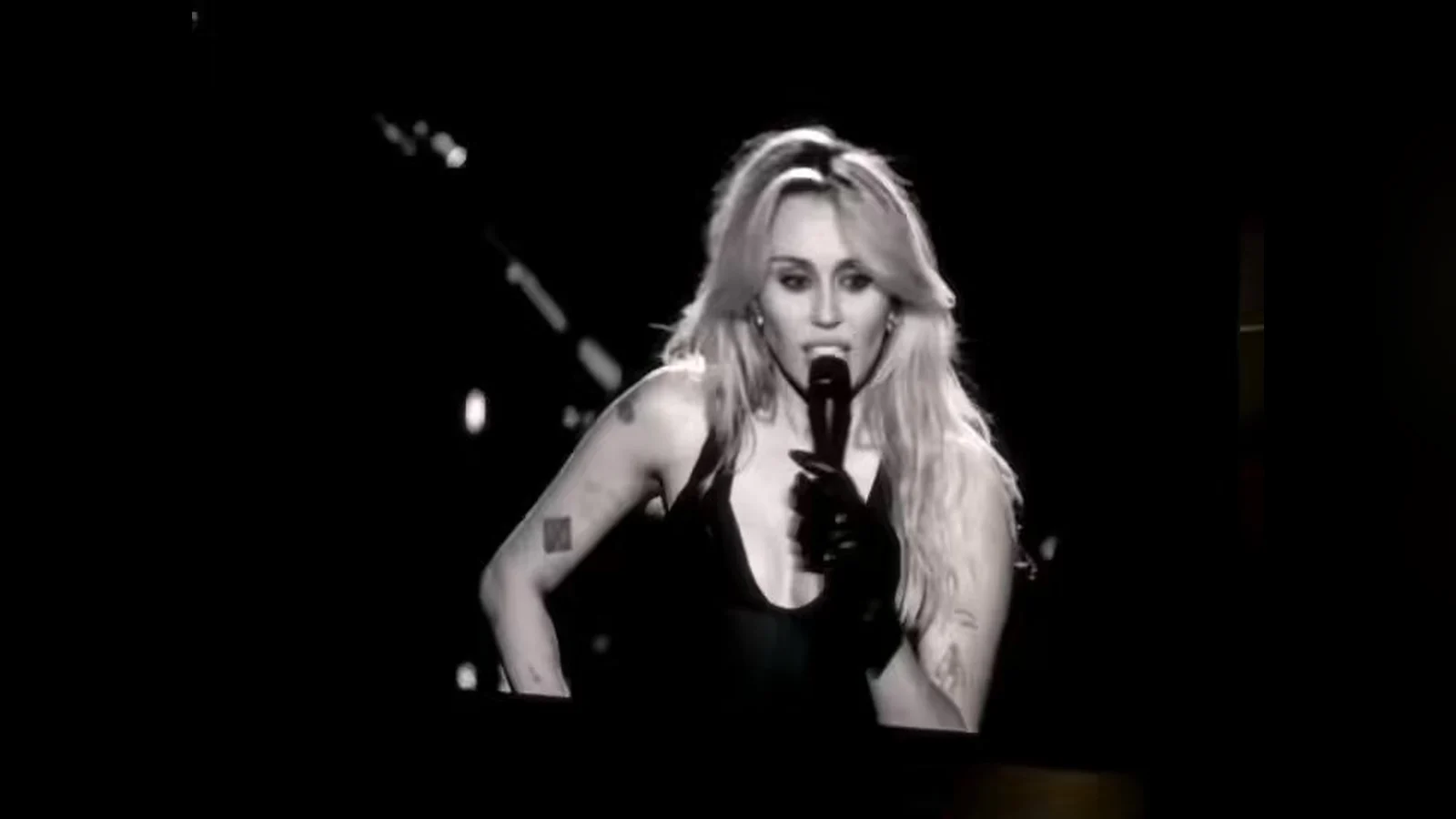 Miley Cyrus cầm micro nói chuyện với khán giả trên màn hình lớn ở Hollywood Bowl