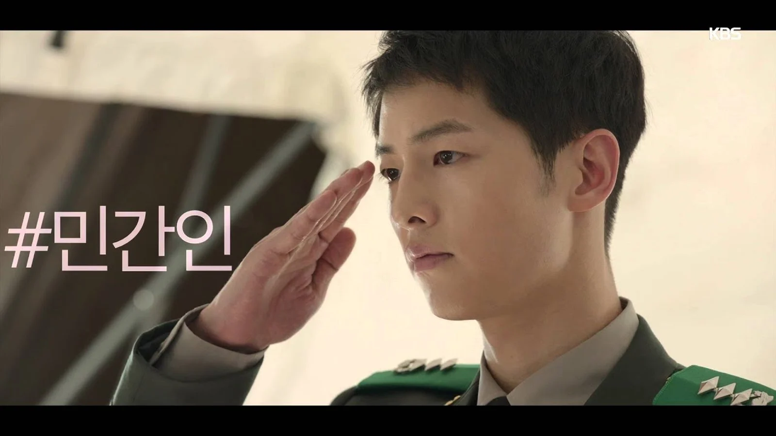 Song Joong Ki trong vai đại úy Yoo Si Jin giơ tay chào kiểu nhà binh trong phim Hậu duệ mặt trời