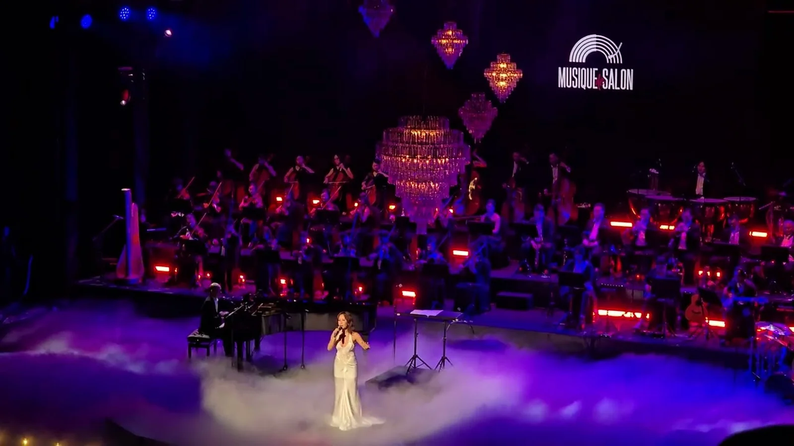 Uyên Linh hát I Have Nothing trên sân khấu có dàn nhạc và đèn chùm Musique de Salon